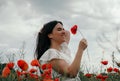 Young happy woman walking in a blooming poppy field Royalty Free Stock Photo