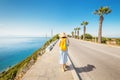 Young happy woman walking by pedestrian road