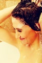 Young happy woman washing hair in bath Royalty Free Stock Photo