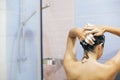 Young happy woman washing her hair with shampoo, foaming with hands. Beautiful  brunette girl taking shower and enjoying relax Royalty Free Stock Photo