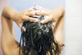 Young happy woman washing her hair with shampoo, hands with foam closeup. Back of beautiful brunette girl taking shower and Royalty Free Stock Photo