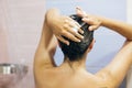 Young happy woman washing her hair with shampoo, hands with foam closeup. Back of beautiful brunette girl taking shower and Royalty Free Stock Photo