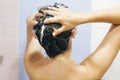 Young happy woman washing her hair with shampoo, hands with foam closeup. Back of beautiful brunette girl taking shower and Royalty Free Stock Photo