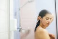 Young happy woman washing her hair, washing away shampoo foam. Portrait of beautiful brunette girl taking shower and enjoying time Royalty Free Stock Photo