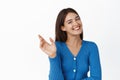 Young happy woman waving hand, greeting you, saying hello and smiling friendly at camera, standing in blue blouse over Royalty Free Stock Photo