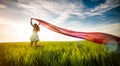 Young happy woman in wheat field with fabric Royalty Free Stock Photo