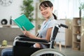 young happy woman in wheelchair reading book Royalty Free Stock Photo