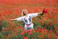 Young happy woman in a white shirt in a poppy field with a bouquet Royalty Free Stock Photo