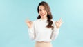 Young happy woman in white t-shirt, winking and showing okay signs, smiling pleased, recommend advertisement, approve product over