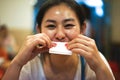 Young happy woman wipes mouth with a white tissue