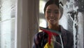 Young happy woman wiping glass surface after spray, cleaning service quality Royalty Free Stock Photo