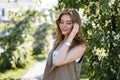 Young happy woman with a wonderful smile in a stylish beige vest in a white T-shirt posing outdoors Royalty Free Stock Photo