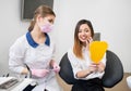Woman with female dentist checking their teeth at mirror after dental procedure in dental clinic. Dentistry Royalty Free Stock Photo