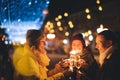 Young happy women girlfriends celebrating new year and christmas on the street in a european city with glasses of champagne and Royalty Free Stock Photo