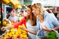 Young happy women shopping vegetables and fruits on the market Royalty Free Stock Photo