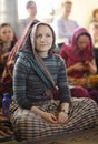 Young Hare Krishna woman listening to the guru preaching in a temple