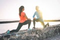 Young Health Couple Stretching Legs Next To The Beach At Sunset - Happy Sportive Lovers Workout Together