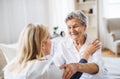 A health visitor talking to a sick senior woman sitting on bed at home. Royalty Free Stock Photo