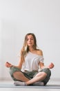 Young healthy beautiful woman practicing yoga at home sitting in lotus pose on yoga mat meditating smiling relaxed with Royalty Free Stock Photo