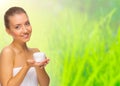 Young healthy girl with body cream jar on spring background Royalty Free Stock Photo