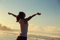 Young woman open arms on sunrise seaside beach Royalty Free Stock Photo