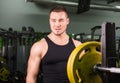 Young healthy man with big muscles holding disk weights in gym. Fitness, sport, training, motivation and lifestyle Royalty Free Stock Photo
