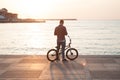 Young healthy man with bike near sea summer sunset outdoor Royalty Free Stock Photo