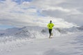 Young healthy sport man running in snow mountains in trail runner hard workout in winter Royalty Free Stock Photo