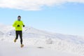 Young healthy sport man running in snow mountains in trail runner hard workout in winter Royalty Free Stock Photo