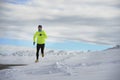 Young healthy sport man running in snow mountains in trail runner hard workout in winter Royalty Free Stock Photo