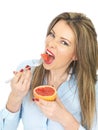 Young Healthy Woman Eating a Pink Grapefruit Royalty Free Stock Photo