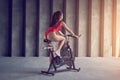 Young healthy woman in red sportswear rides on the exercise bike. Sport and healthy lifestyle concept Royalty Free Stock Photo