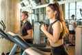 Young healthy woman jogging on exercise machine in health club. Sporty people running on treadmill in the gym. Royalty Free Stock Photo