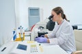 Young hematologist looks into the eyepiece of a microscope