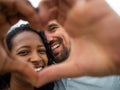 Young heterosexual couple smiling making a heart symbol with their hands. Concept of honeymoon, valentine& x27;s day Royalty Free Stock Photo