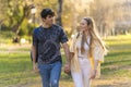 Young heterosexual couple walking in a park and looking each other Royalty Free Stock Photo