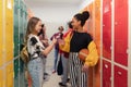 Young high school students meeting and greeting near locker in campus hallway, back to school concept. Royalty Free Stock Photo