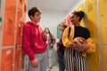 Young high school students meeting and greeting near locker in campus hallway, back to school concept. Royalty Free Stock Photo