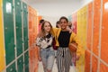 Young high school students meeting and greeting near locker in campus hallway talking and walking together. Royalty Free Stock Photo