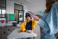 Young high school teacher giving lesson to students with VR goggles in classroom Royalty Free Stock Photo