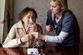 Young high-skilled pleasant woman doctor putting on nebulizer mask on face of her elderly female patient to make