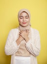 young hijab women smile asking silent prayers holding holding chest