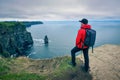 Young hiker standing at the cliffs of Moher