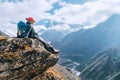 Young hiker backpacker female sitting on cliff edge and enjoying the Imja Khola valley during high altitude Everest Base Camp EBC Royalty Free Stock Photo