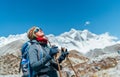 Young hiker backpacker female taking brake in hike walking during high altitude Everest Base Camp EBC route with snow Himalayan