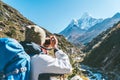 Young hiker backpacker female taking photo mountain view during high altitude Acclimatization walk. Everest Base Camp trekking