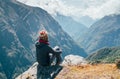 Young hiker backpacker sitting on the peak edge and enjoying mountains view valley during high altitude Everest Base Camp EBC