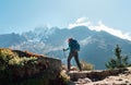 Young hiker backpacker woman using trekking poles enjoying Everest Base Camp trekking route with Thamserku 6608m mountain on