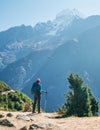 Young hiker backpacker woman using trekking poles enjoying the Thamserku 6608m mountain with flying rescue helicopter during high Royalty Free Stock Photo