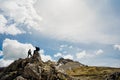 Young hiker couple climbing on the peak of mountain cliff.Active hiking trip lifestyle.Vacation in nature.Climbers wearing outdoor